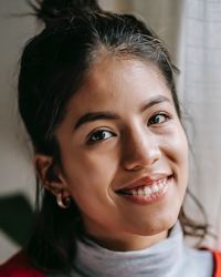 Cheerful volunteer woman in red uniform by Liza Summer via Pexels.com.