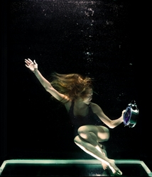 Woman underwater holding round gray clock by Engin Akyurt via Pexels.com.